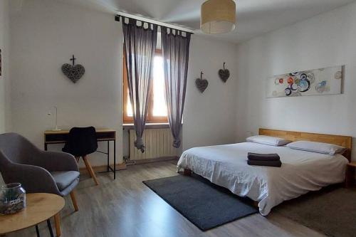 - une chambre avec un lit, une chaise et un bureau dans l'établissement Accogliente Bilocale In Zona Centrale - alloggio uso turistico - VDA - Aosta - 0318, à Aoste