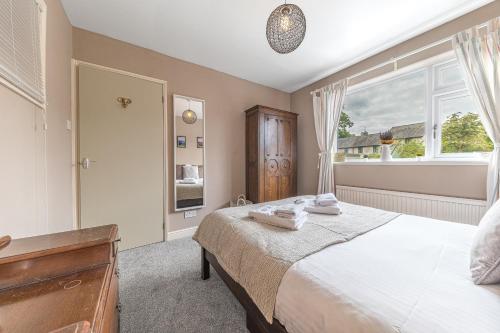 a bedroom with a bed and a window at Couples getaway in central Windermere, ground floor flat with parking in Windermere