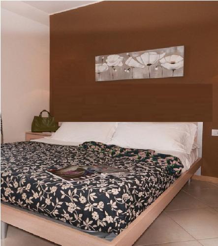 una camera da letto con un letto con un piumone bianco e nero di residence a Parma