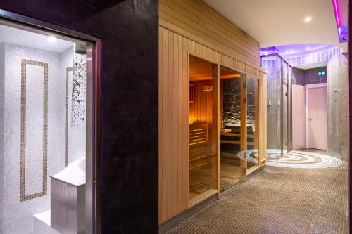 uma casa de banho com uma cabina de duche ao nível do chão e uma porta de vidro em Le Lana em Courchevel