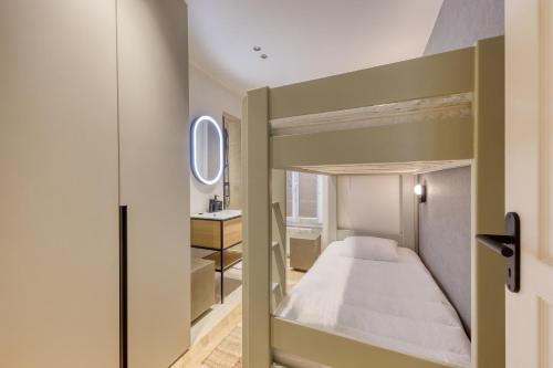 une chambre avec un lit superposé et un miroir dans l'établissement Les Reflets des Martyrs I 3CH I 2SDB I Clim, à Paris