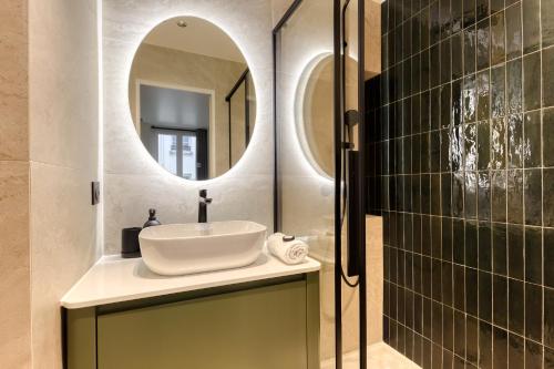 une salle de bain avec un lavabo et un miroir dans l'établissement Les Reflets des Martyrs I 3CH I 2SDB I Clim, à Paris