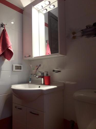 uma casa de banho com um lavatório, um espelho e um WC. em Patroclos SeaView em Sounio