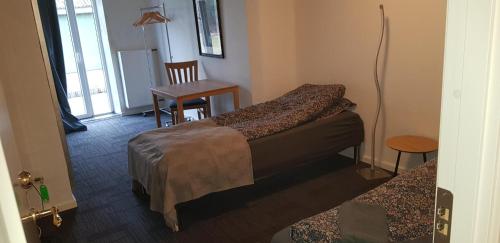 a room with two beds and a table and a chair at Kyndestoft Bed & Breakfast in Holstebro