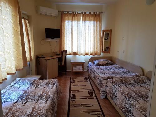 a hotel room with two beds and a television at Hotel Fantasy in Lyubimets