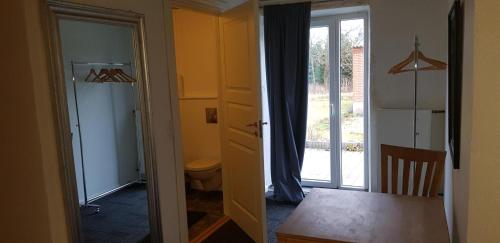 a hallway with a room with a toilet and a table at Kyndestoft Bed & Breakfast in Holstebro