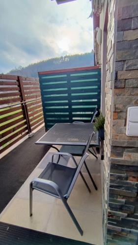a table and a chair on a balcony at Guest House Sherpa in Moravská Třebová