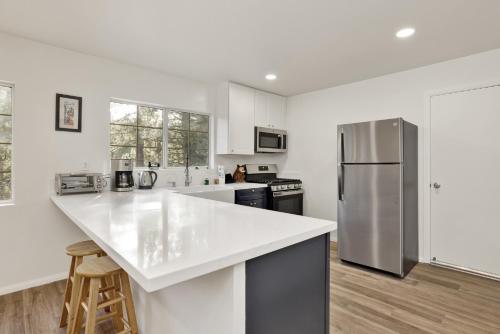 a kitchen with white walls and a stainless steel refrigerator at 2358- Oso Grande cabin in Big Bear Lake