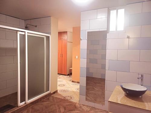 La salle de bains est pourvue d'une douche en verre et de toilettes. dans l'établissement AVANI HOSPEDAJE, à Lligua
