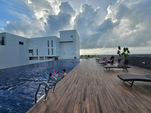 una piscina en un edificio con gente en el agua en Charming 3BR Podium 7pax Walk to Aeon, en Kuching