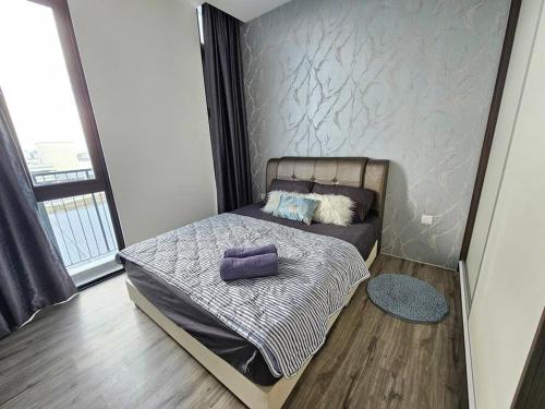 Un dormitorio con una cama con almohadas moradas. en Charming 3BR Podium 7pax Walk to Aeon, en Kuching