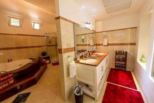 a large bathroom with a tub and a sink at Villa Jambalaya in Maho Reef