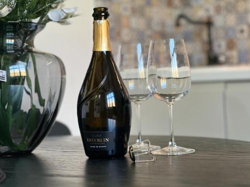 - une bouteille de vin assise sur une table avec deux verres dans l'établissement Great Living Apartments, à Karlovy Vary