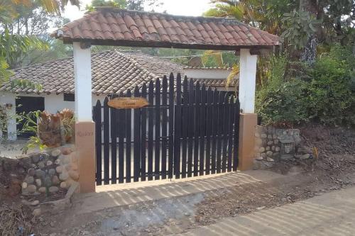 ein Tor vor einem Haus mit einem Dach in der Unterkunft Departamento Raíces in Curití