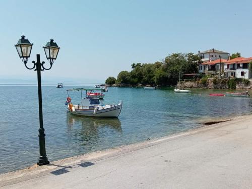 a boat in the water next to a street light at Katerina's SeaSide in Afissos