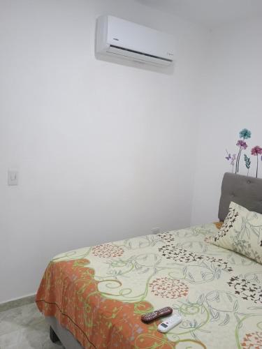ein Schlafzimmer mit einem Bett mit zwei Fernbedienung in der Unterkunft Alojamiento valerie in Neiva