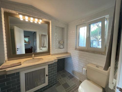 a bathroom with a sink and a mirror and a toilet at Private Villa in Quinta da Marinha with golf view! in Cascais