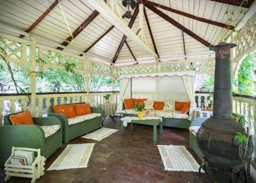 an outdoor living room with couches and a fireplace at Conacul Malul Alb in Râmnicu Vâlcea