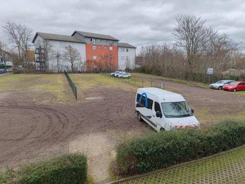 biały van zaparkowany na parkingu w obiekcie Hotel Alina w mieście Wiesbaden