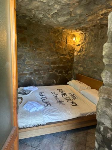 uma cama num quarto com paredes de pedra e uma cama sidx sidx em La Grotta di Leonardo a Vinci em Quarrata