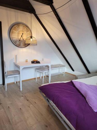 a room with a table and a clock on the wall at Watt ne Bude in Büsum - Krabbeliebe Büsum in Büsum