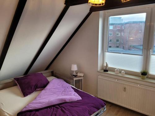 Watt´ne Bude in Büsum في بوسوم: غرفة نوم بسرير ونافذة كبيرة