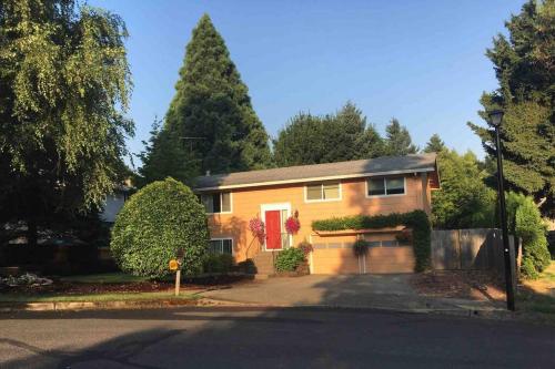 a yellow house with a red door on a street at West Linn Relaxing Entire Home WiFi TV Yard BBQ Eateries in West Linn