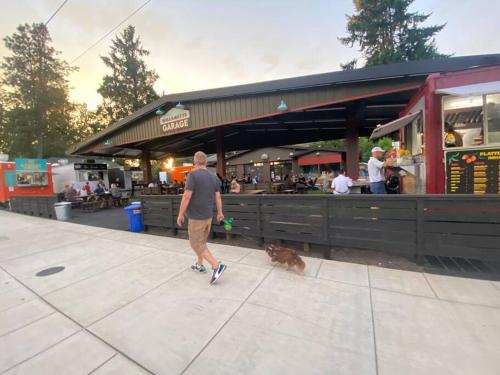 a man walking a dog in front of a restaurant at West Linn Relaxing Entire Home WiFi TV Yard BBQ Eateries in West Linn