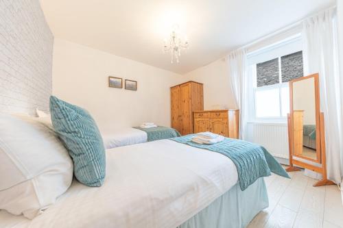 - une chambre avec 2 lits et une fenêtre dans l'établissement Enjoy relaxing family breaks in this central Ambleside apartment with parking, à Ambleside