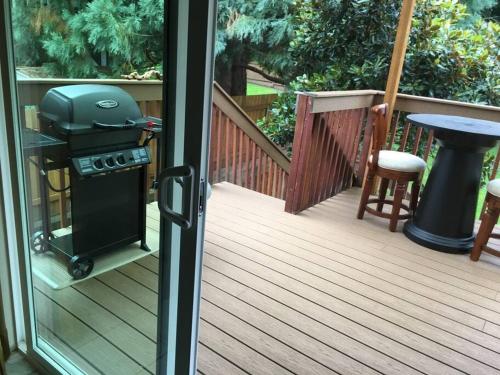 a grill sitting on a porch with a table at West Linn Relaxing Entire Home WiFi TV Yard BBQ Eateries in West Linn