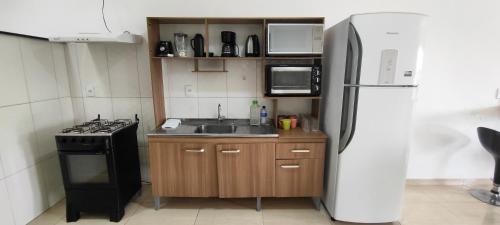 a kitchen with a stove and a refrigerator at Pousada e Casa Praias de Penha in Penha