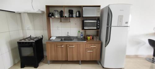 a kitchen with a stove and a refrigerator at Praias de Penha SC in Penha