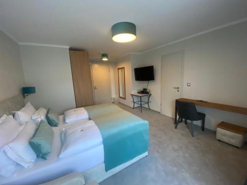 a hotel room with a large bed and a desk at Hotel Radetzky in Sankt Gilgen