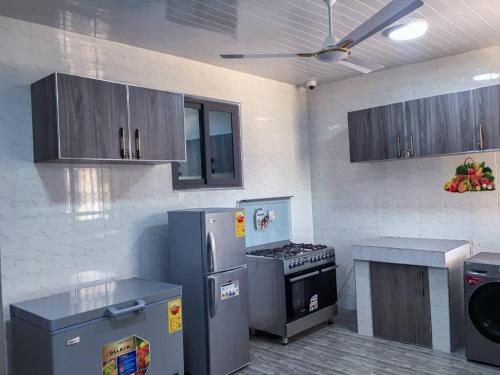a kitchen with stainless steel appliances and a stove at Pro CeDi Ventures Self-catering in Kasoa