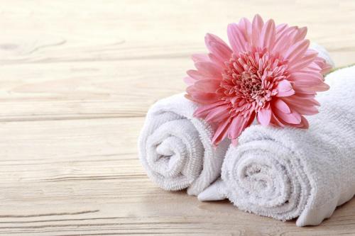 a pile of towels with a pink flower on top at Rivoli Suites and Spa in Hurghada