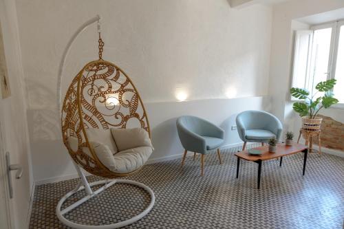 a room with a swing chair and two chairs and a table at CASA NINETTA GUEST HOUSE in Urbisaglia