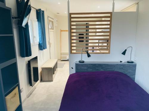 a bathroom with a purple tub in a room at Le Clos Robinson in Martin-Église