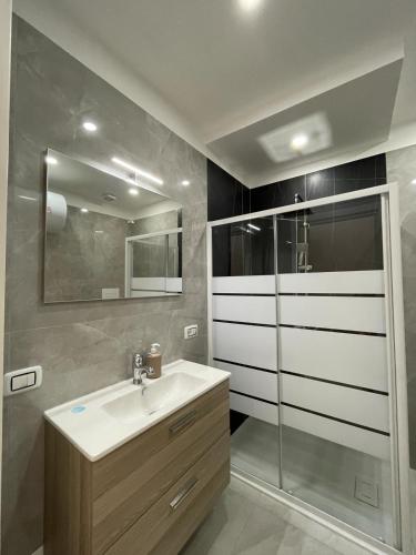 een badkamer met een wastafel en een glazen douche bij Ercolano Beautiful house in Ercolano