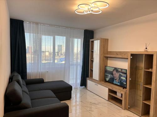 ein Wohnzimmer mit einem Sofa und einem Flachbild-TV in der Unterkunft Apartament 2 camere Sector 1 in Bukarest