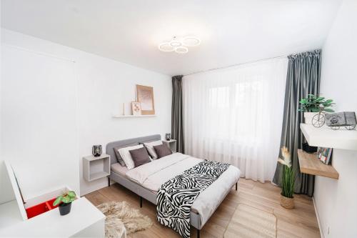 a white bedroom with a bed and a window at High quality family - Calliope apartment in Timişoara