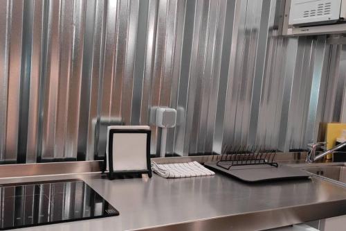 a kitchen with a counter with a cell phone on it at Estudio Industrial a 9' del centro en metro in San Juan de Aznalfarache