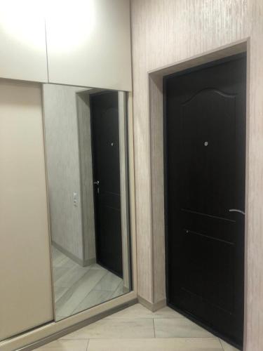 dois espelhos num quarto com duas portas em Апартаменты в Тбилиси em Tbilisi