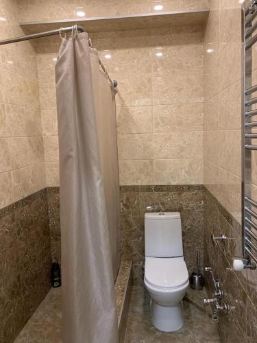 y baño con aseo y cortina de ducha. en Апартаменты в Тбилиси, en Tiflis