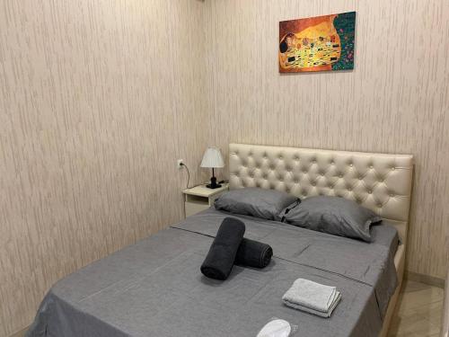um quarto com uma cama com cabeceira e uma fotografia em Апартаменты в Тбилиси em Tbilisi