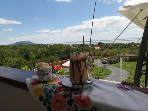 a table with two drinks on top of a balcony at Jurta Hotel Balatongyörök in Balatongyörök