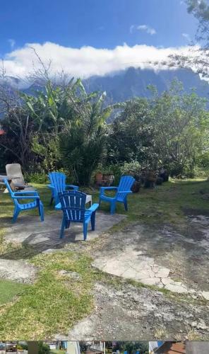3 sillas azules sentadas en un patio con vistas en Le Temps des prunes - 4 personnes, en Cilaos