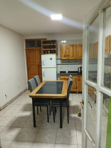 cocina con mesa de madera y sillas en alojamiento la pipi en Las Heras