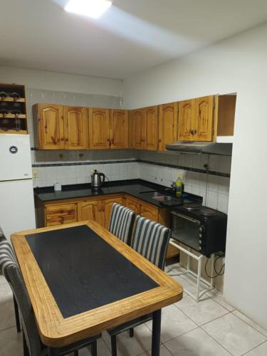 uma cozinha com armários de madeira e uma mesa de madeira em alojamiento la pipi em Las Heras