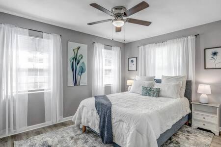 Un dormitorio con una cama y un ventilador de techo. en Gorgeous Pool Home - 5 Min from San Marco, en Jacksonville