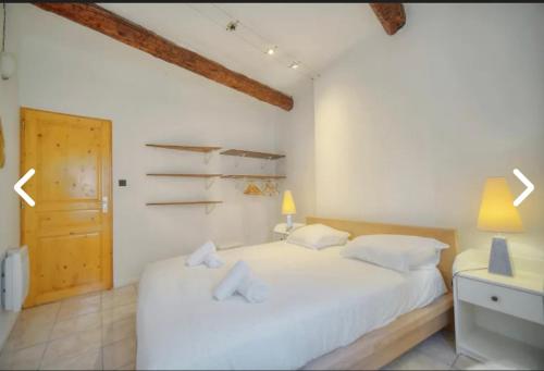 - une chambre avec un lit blanc et une porte en bois dans l'établissement Appartement Canne 1 chambre - 12RP, à Cannes